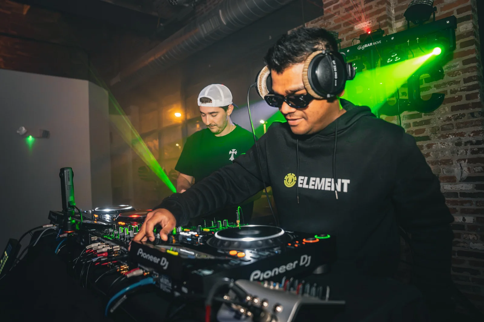 DJs performing under green lights at the EDM LANC September 25 Local Artist Feature Series